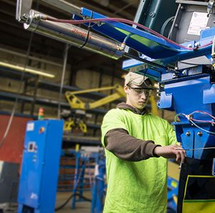 Worker placing bag on bagging machine fill spout